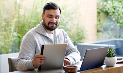 Man using Windows 11 laptop and tablet